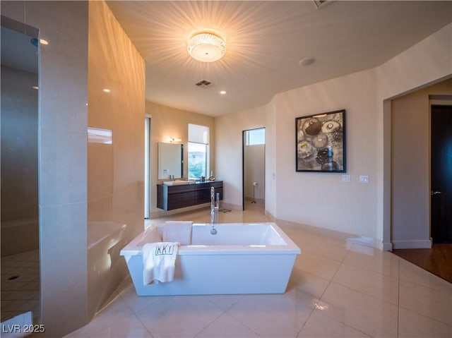 bathroom with a garden tub, vanity, visible vents, and tile patterned floors