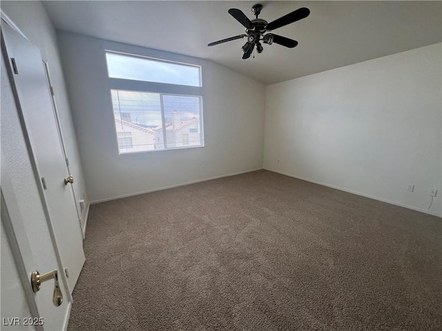 spare room with ceiling fan, baseboards, vaulted ceiling, and carpet flooring