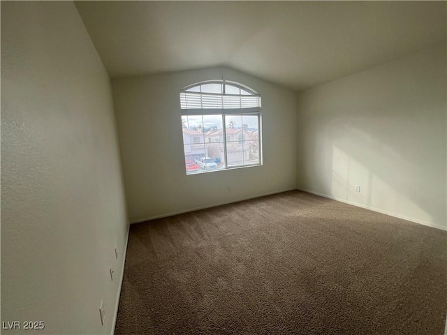 empty room featuring lofted ceiling and carpet floors