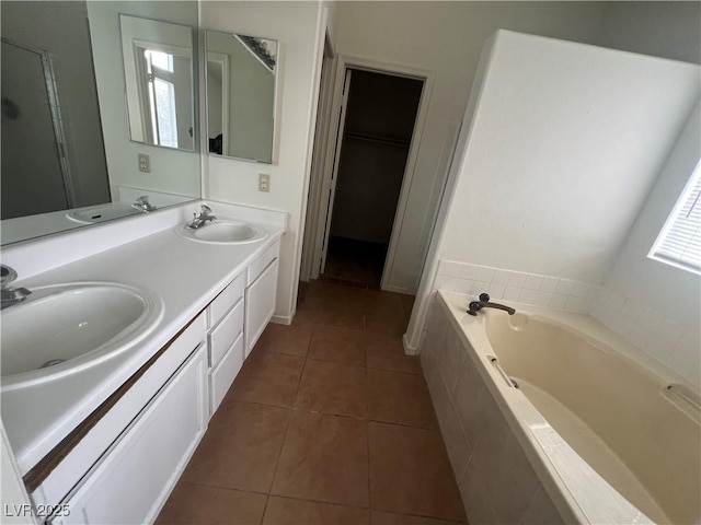 full bathroom with a garden tub, a sink, and tile patterned floors