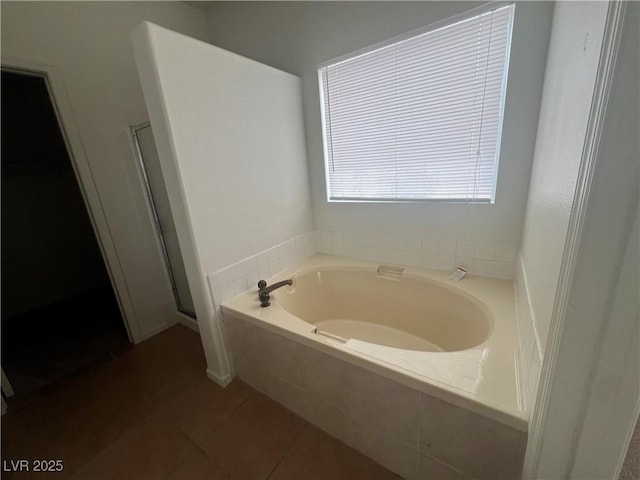 full bathroom featuring a stall shower, a garden tub, and tile patterned floors