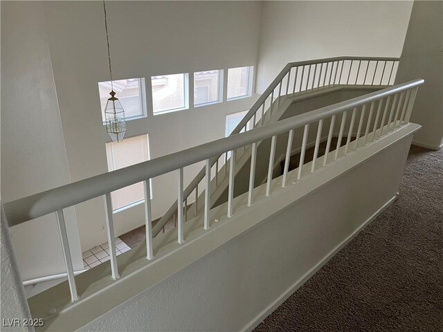 stairway featuring carpet flooring and baseboards