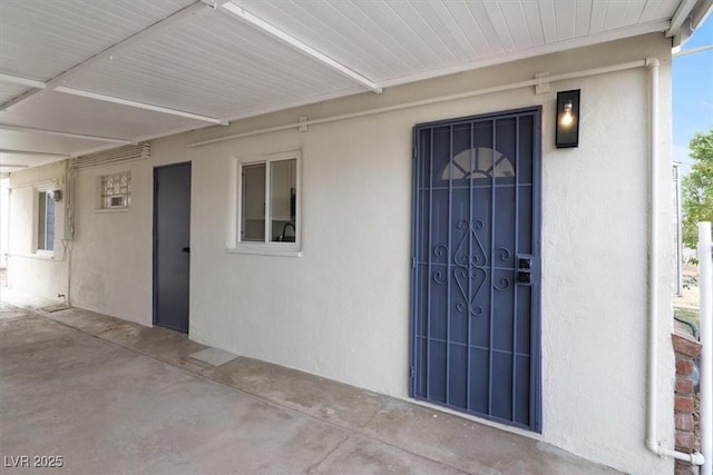 property entrance with stucco siding