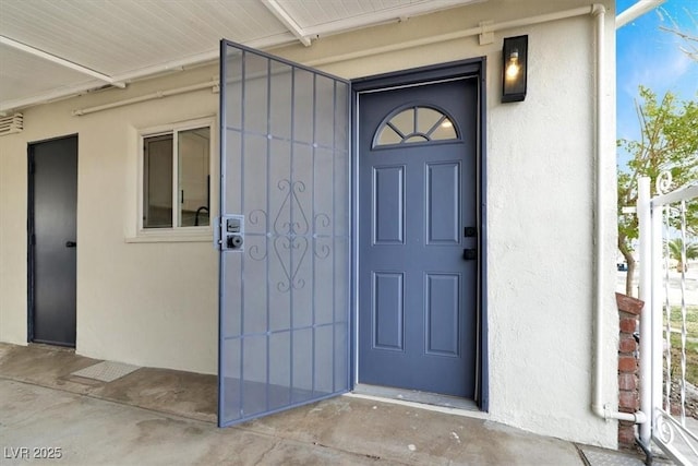 entrance to property featuring stucco siding