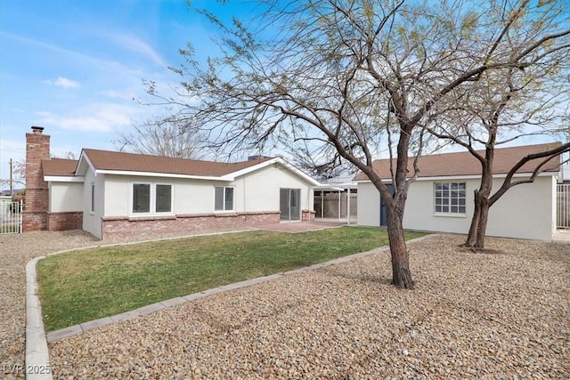 ranch-style house with brick siding, stucco siding, a chimney, a patio area, and a front yard