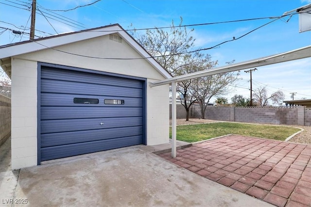 detached garage featuring driveway and fence