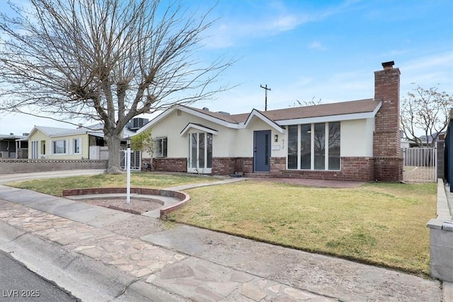 ranch-style house featuring brick siding, a chimney, stucco siding, fence, and a front lawn