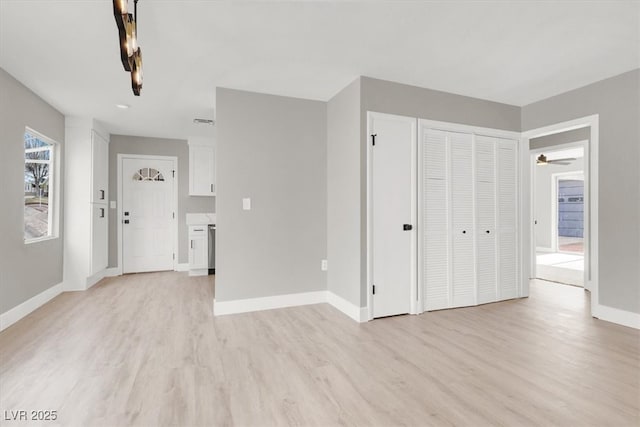 unfurnished living room with light wood-style floors and baseboards