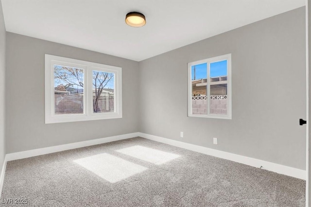 carpeted spare room featuring baseboards