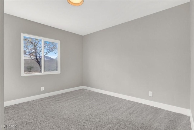 empty room featuring carpet and baseboards