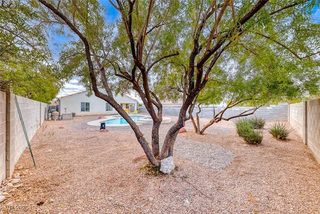 view of yard featuring a fenced in pool, a fenced backyard, and central AC