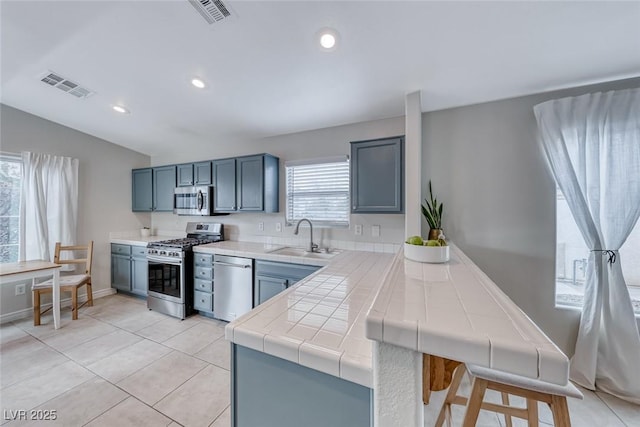 kitchen featuring appliances with stainless steel finishes, visible vents, a sink, and light tile patterned floors