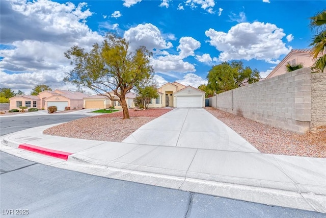 view of front facade with a garage, concrete driveway, and fence