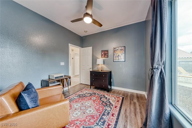 office with a ceiling fan, baseboards, wood finished floors, and a textured wall