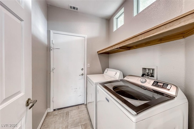 laundry area featuring light tile patterned floors, laundry area, visible vents, baseboards, and washer and dryer