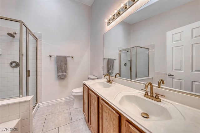 bathroom with double vanity, a stall shower, a sink, and tile patterned floors