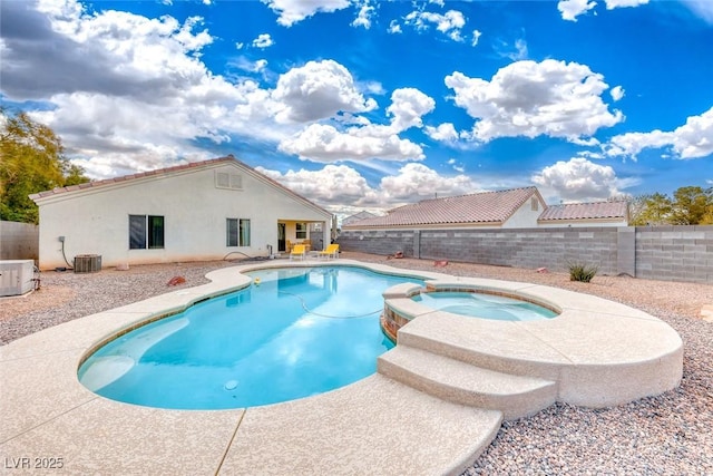 view of pool with a patio area, a pool with connected hot tub, a fenced backyard, and central AC