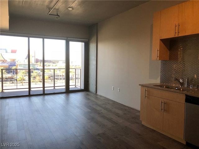 kitchen with dark wood-style flooring, a city view, backsplash, stainless steel dishwasher, and a sink