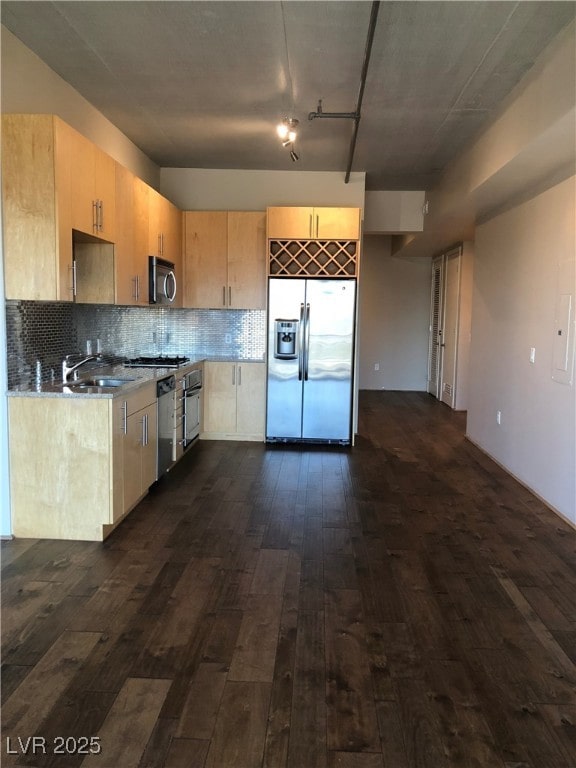 kitchen with tasteful backsplash, dark wood finished floors, appliances with stainless steel finishes, light brown cabinetry, and a sink