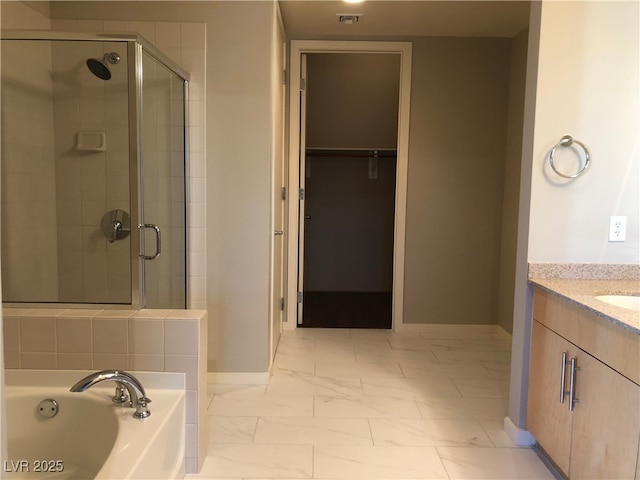 bathroom with marble finish floor, a garden tub, visible vents, a spacious closet, and a stall shower