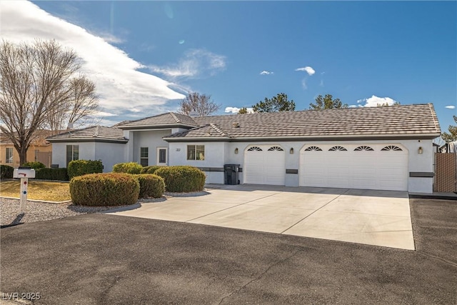 view of front facade featuring an attached garage, driveway, and stucco siding