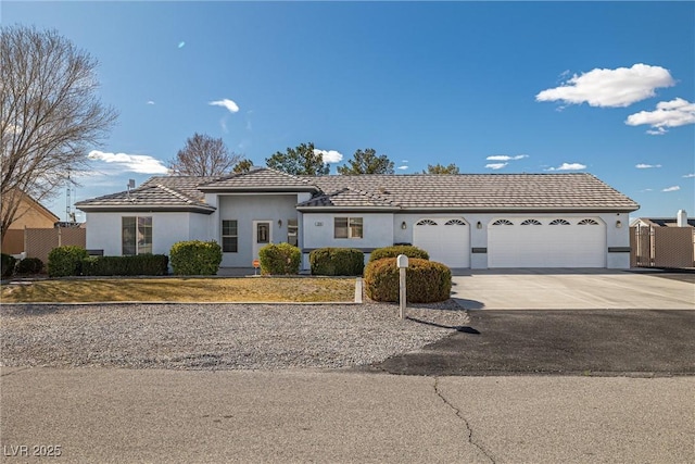 view of front facade with driveway, an attached garage, and stucco siding