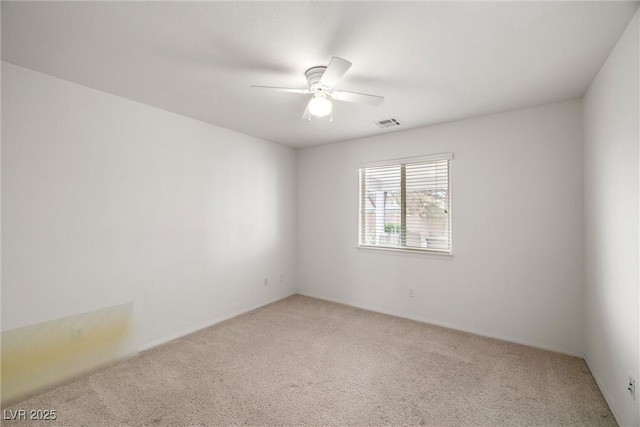 unfurnished room featuring light carpet, visible vents, and a ceiling fan