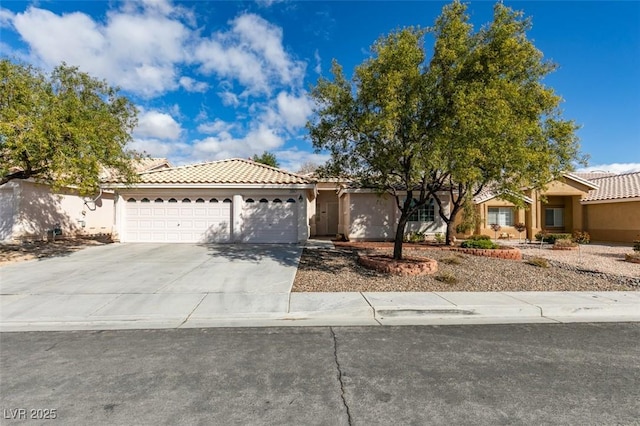 view of front of property with a garage, concrete driveway, a tile roof, and stucco siding