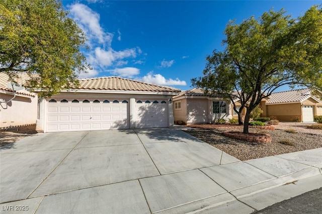 ranch-style house featuring an attached garage, a tile roof, concrete driveway, and stucco siding