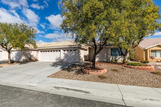 view of front of property featuring a garage, driveway, a tile roof, and stucco siding