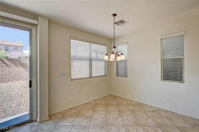 empty room with visible vents, a notable chandelier, baseboards, and light tile patterned flooring