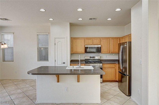 kitchen with visible vents, an island with sink, stainless steel appliances, a sink, and recessed lighting