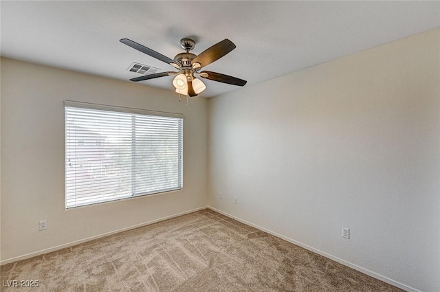 spare room with light carpet, ceiling fan, and visible vents