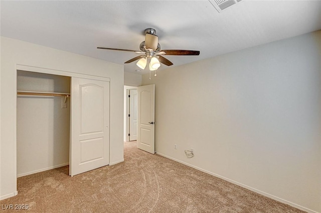 unfurnished bedroom featuring light colored carpet, a ceiling fan, baseboards, visible vents, and a closet