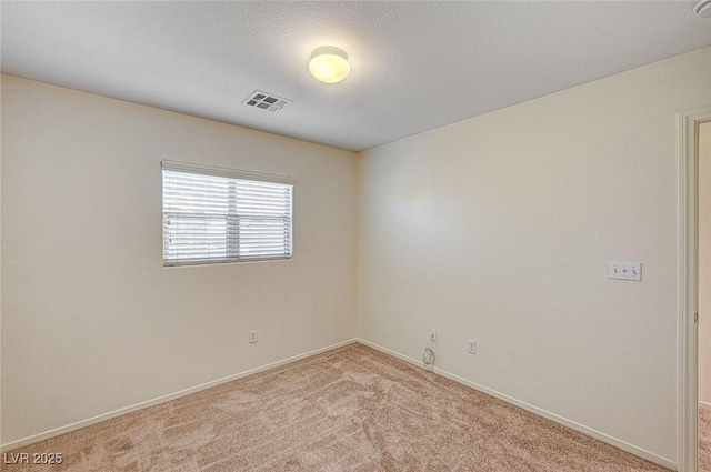 unfurnished room with visible vents, light carpet, and baseboards