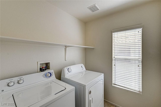 laundry room with laundry area, visible vents, washer and clothes dryer, and a healthy amount of sunlight