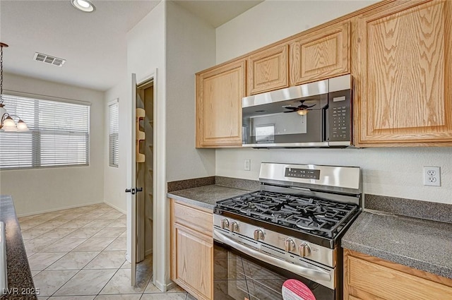 kitchen with light tile patterned floors, light brown cabinets, visible vents, appliances with stainless steel finishes, and dark countertops