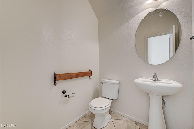 bathroom with toilet and baseboards