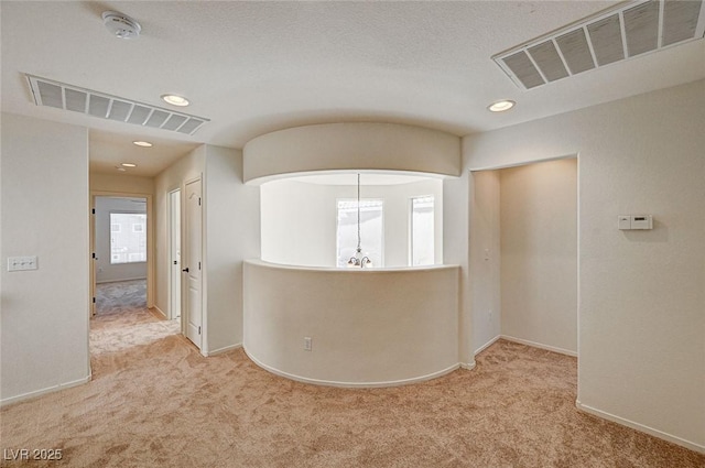 hall featuring an inviting chandelier, carpet, and visible vents