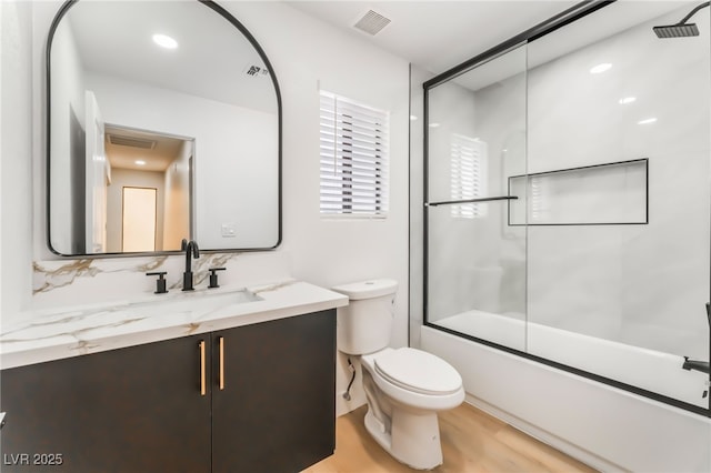 full bath with visible vents, toilet, wood finished floors, combined bath / shower with glass door, and vanity