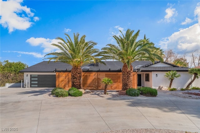 view of front of home featuring concrete driveway, an attached garage, and stucco siding