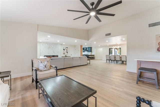 living area with light wood-type flooring, a fireplace, and visible vents