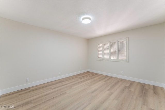 spare room with light wood-style floors and baseboards