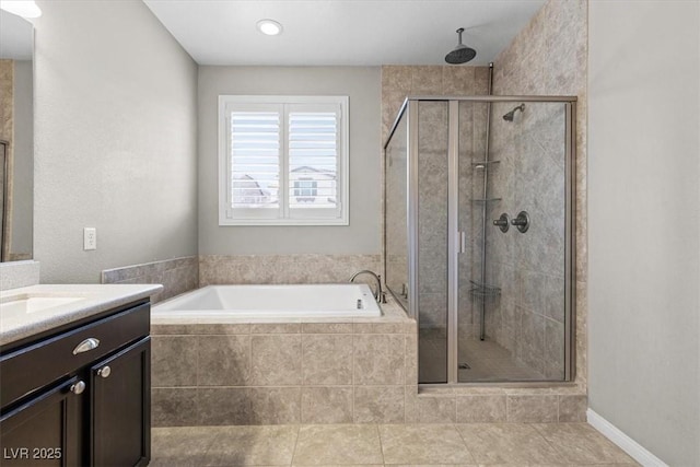 bathroom with a garden tub, a shower stall, tile patterned floors, and vanity