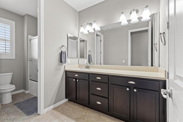 bathroom featuring tile patterned flooring, toilet, bath / shower combo with glass door, vanity, and baseboards