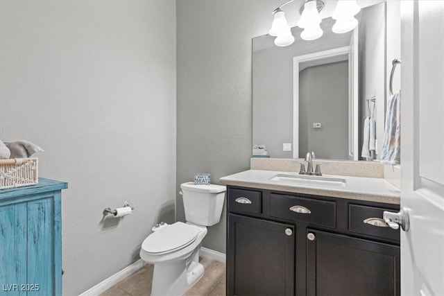 half bathroom with toilet, tile patterned flooring, baseboards, and vanity