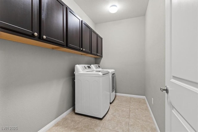 laundry room with cabinet space, light tile patterned floors, baseboards, and independent washer and dryer