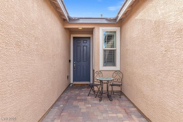 property entrance featuring a patio and stucco siding