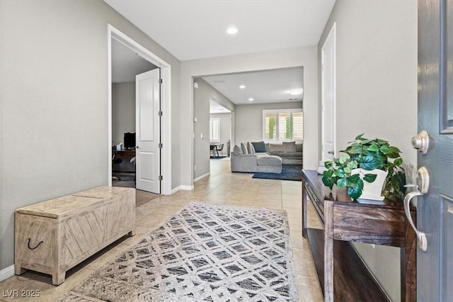 hall featuring light tile patterned floors, baseboards, and recessed lighting