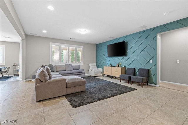 living area featuring light tile patterned floors, an accent wall, baseboards, and recessed lighting